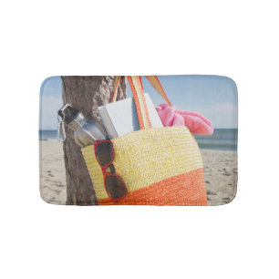 Tasche, die am Baum-Stamm an Sandy-Strand hängt Badematte