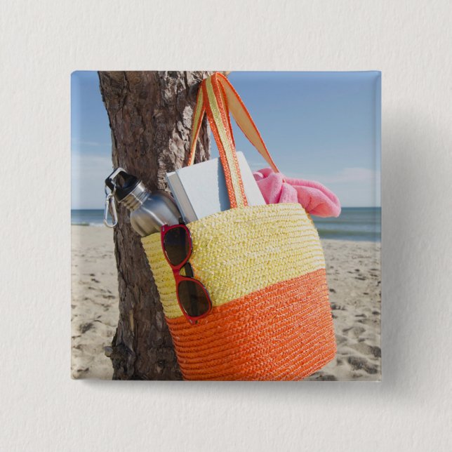 Tasche, die am Baum-Stamm an Sandy-Strand hängt Button (Vorderseite)