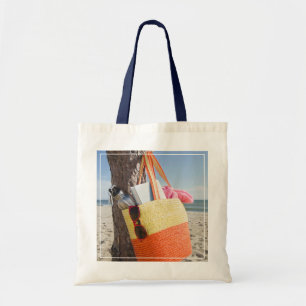 Tasche, die am Baum-Stamm an Sandy-Strand hängt Tragetasche