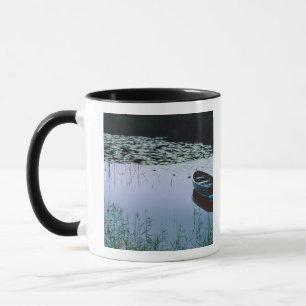 Tasse Bateau à rames sur un petit lac entouré d'eau