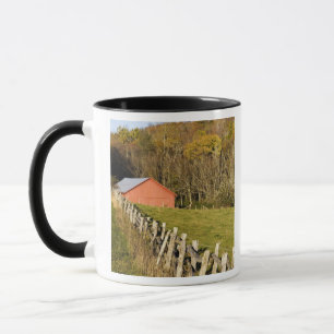 Tasse Grange rouge et rangée de clôture le long de Blue