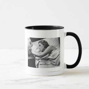 Tasse Jeune femme se trouvant sur le lit arrêtant la