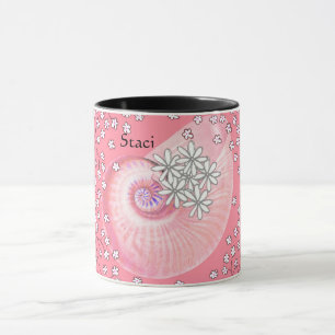 Tasse mit Gänseblümchen und Muschel in Rosa