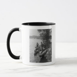 Tasse Trois chasseurs avec des canoës au rivage
