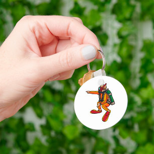 Taucher in orangem Neoprenanzug zeigt Schlüsselanhänger