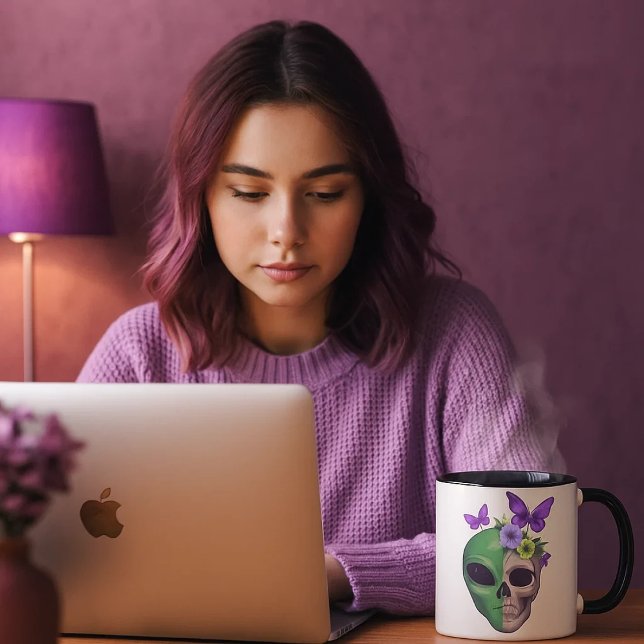 Taza blanca con diseño calavera alien y mariposa – tasse (Una joven mirando sus cosas en el ordenador mientras se toma una bebida caliente en su taza favorita)