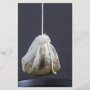 Tee-Eutel hängt in einer Tasse Briefpapier
