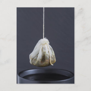 Teebeutel hängt in einer Tasse Postkarte