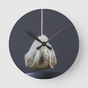 Teebeutel hängt in einer Tasse Runde Wanduhr