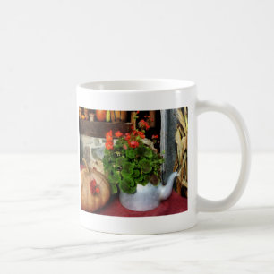 Teekanne gefüllt mit Pelargonien Kaffeetasse