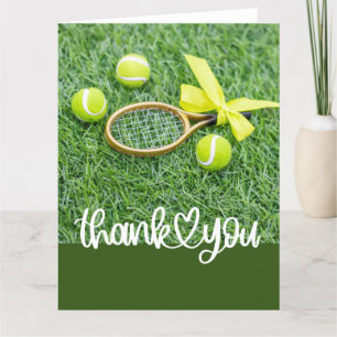 Tennis mit Schlägern und Kugeln auf grünem Gras Dankeskarte