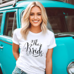 The Bride Black Script Personalisiert Wedding T-Shirt<br><div class="desc">Das Bride Hochzeitsskript-Shirt bietet moderne,  schwarz wirbelnde Kalligraphie-Schriftzeichen mit elegantem,  individuellem Future Mrs. Text,  den Sie mit einem Nachnamen auf der Rückseite personalisieren können. Sehen Sie sich unsere koordinierenden Brautparty-Designs an!</div>