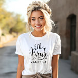 The Bride Black Script Personalisiert Wedding T-Shirt<br><div class="desc">Wedding The Bride Shirt bietet moderne,  schwarz wirbelnde Kalligraphie-Skripte mit elegantem Vornamen,  den Sie personalisieren können. Sehen Sie sich unsere koordinierenden Brautparty-Designs an!</div>