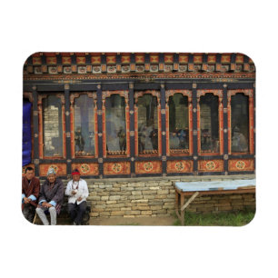 Three men sit on a bench at the Memorial Chorten Magnet