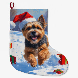 Tibet-Terrier läuft im Schnee mit Weihnachtsmütze Großer Weihnachtsstrumpf
