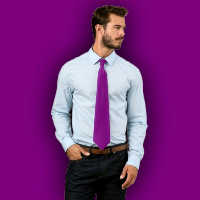 Tie  violet uni -  cravate une couleur (Man wearing a solid purple necktie, standing against a purple background that matches the tie.
)