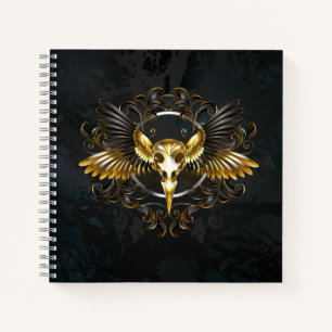 Totenkopf eines goldenen Vogels auf schwarzem Hint Notizbuch
