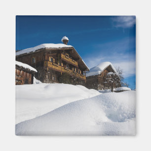 Traditionelle Holzhütten im Schnee Magnet
