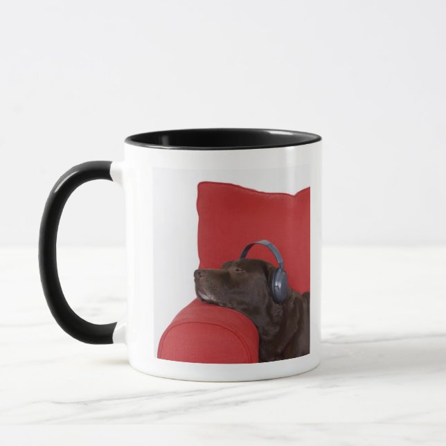Tragende Kopfhörer Labradors, die auf Sofa liegen Tasse (Links)