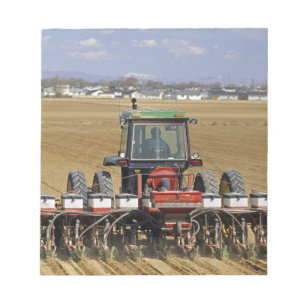Traktor zieht eine Mais-Sämaschine. Notizblock