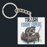 Trash Fishin' Expert Raccoon Schlüsselanhänger<br><div class="desc">Are you a fan of raccoons and fishing? This funny 'Trash Fishin' Expert' design features a master raccoon angler on a wooden dock with his gear. Perfect for anyone who loves trash panda memes, outdoor fishing trips, and a good laugh. This vintage-style illustration is a great gift for fishers, outdoorsmen,...</div>