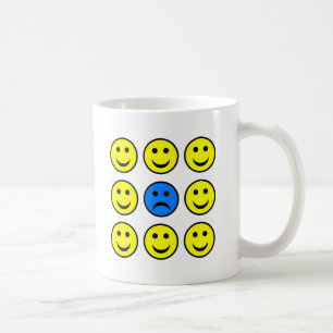Trauriges Gesicht in einer Menge von glücklichem Kaffeetasse