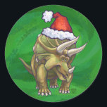 Tricerops Christmas Green Runder Aufkleber<br><div class="desc">Animal Parade Festive Triceratops Weihnachtsdesign zeigt unsere lustige Illustration eines Triceratops mit einer Feiertagsroten Weihnachtsmannmütze und stehend in einer schneebedeckten Landschaft gegen eine blaue Sternennacht. Unsere ursprüngliche Dinosaurierkunst wurde von unserem talentierten Kinderillustrator Traci Van Wagoner gemalt. Auf vielen unserer lustigen Urlaubsgeschenke und Accessoires finden Sie unseren niedlichen Triceratops Dinosaurier von...</div>