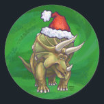 Tricerops Christmas Green Runder Aufkleber<br><div class="desc">Animal Parade Festive Triceratops Weihnachtsdesign zeigt unsere lustige Illustration eines Triceratops mit einer Feiertagsroten Weihnachtsmannmütze und stehend in einer schneebedeckten Landschaft gegen eine blaue Sternennacht. Unsere ursprüngliche Dinosaurierkunst wurde von unserem talentierten Kinderillustrator Traci Van Wagoner gemalt. Auf vielen unserer lustigen Urlaubsgeschenke und Accessoires finden Sie unseren niedlichen Triceratops Dinosaurier von...</div>