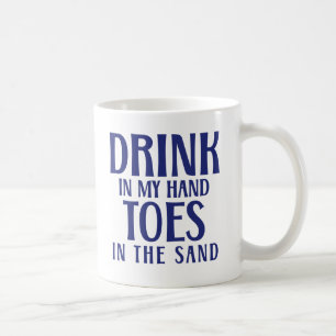 Trinken Sie in meinen Handzehen am Sandstrand Kaffeetasse