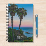 Tropical Island Paradise Sunset Personalisierter N Planer<br><div class="desc">Dieses Design besticht durch eine tropische Insel mit Palmen und ein ruhiges Meer mit Sonnenuntergang und einem bearbeitbaren personalisierten Namen,  der in der beliebten modernen Typografie geschrieben wurde. Personalisieren Sie diese,  indem Sie den Text im Textfeld bearbeiten oder ohne Text löschen. #tropical #sunset #beach #ocean #personalisiert #planner #gift</div>