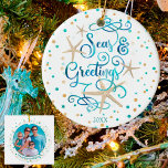 Tropische Frohe Festtage Beach Script Foto Keramik Ornament<br><div class="desc">Eine lustige Drehung auf den traditionellen "Grüße der Jahreszeit" mit den Worten SEAS & GREETINGS mit einem tropischen, Küsten- oder Strandlook und fühlen sich zu Ihrem Weihnachtsurlaub oder Strandhaus. Die moderne, elegante Schrift-Typografie ist in einer entspannenden türkisblauen Meeresfarbe, die von Seestern betont wird und von türkisfarbenen und sandbraunen Punkten umgeben...</div>