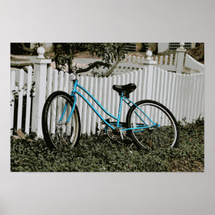 Türkis Fahrrad an einem weißen Lattenzaun gelehnt Poster