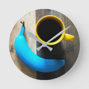 Türkisfarbene Banane und Tasse mit gelbem Kaffee - Runde Wanduhr