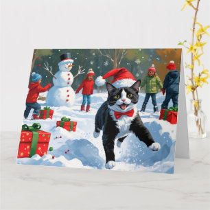 Tuxedo Katze läuft im Schnee mit Weihnachtsmütze Karte