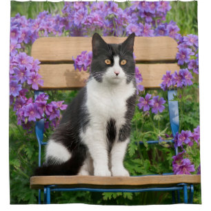 Tuxedo Katze sitzt auf einem Gartenstuhl mit Blume Duschvorhang