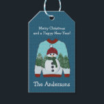 Ugly Christmas Sweater | Niedlich Snowman Geschenkanhänger<br><div class="desc">Das Design zeichnet sich durch einen wirklich niedlichen, hässlichen Pullover aus, mit einem Schneemann mit grünem Schal und einer roten Mütze auf einem schneebedeckten Kiefernwald. Blau gestrickter Wollhintergrund. Individuell gestaltbare Urlaubsnachrichten und personalisieren mit Namen oder Familienname. Karo in der Ugly Sweater Kollektion für mehr Spaß beim Dekorieren von Party, Party,...</div>