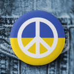 ukrainische Flagge Friedenssymbol Ukraine gegen Kr Button<br><div class="desc">Ukraine Anti-Krieg-Taste mit einem weißen Friedenssymbol auf einem blauen und gelben ukranischen Fahnen Hintergrund.</div>