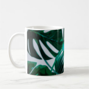 Unscharfer abstrakter Hintergrund der grünen Pflan Kaffeetasse