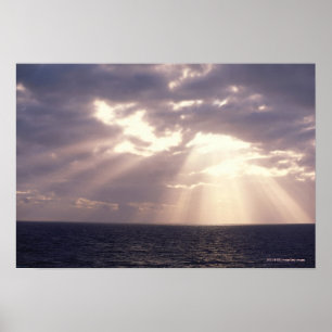 Untergehende Sonne, die durch Wolken über Ozean Poster