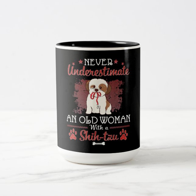 Unterschätzen Sie niemals eine alte Frau mit einem Zweifarbige Tasse (Mittel)