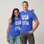 USA 1776 T - Shirt<br><div class="desc">USA und 1776 in einem einzigartigen Schriftart ist in Weiß auf diesem unisex T - Shirt mit roten und blauen Streifen und einem goldenen Stern hervorgehoben. Wählen Sie Ihre T - Shirt Farbe und Größe aus den verfügbaren.</div>