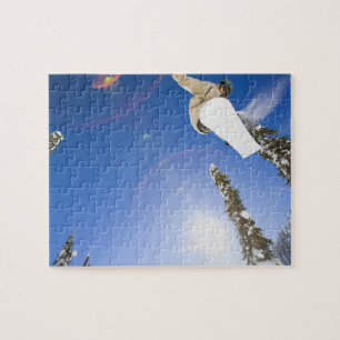 USA, Montana, Whitefish, Young man snowboarding