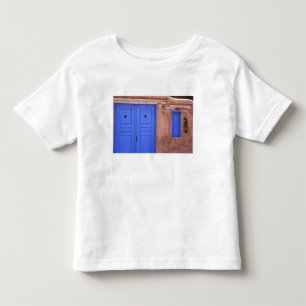 USA, New Mexico, Santa Fe. Blick auf blaue Tür und Kleinkind T-shirt
