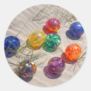 USA, Oregon. Farbenfrohe Glasflöße auf Sanddüne Runder Aufkleber