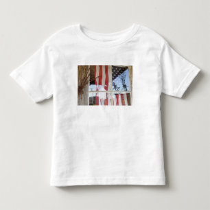 USA, Oregon, Shaniko. Flagge im Fenster nahe bei Kleinkind T-shirt