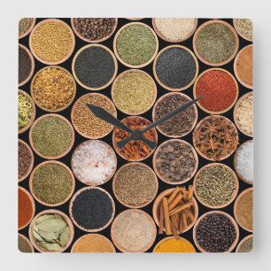 Various spices and food ingredients quadratische wanduhr