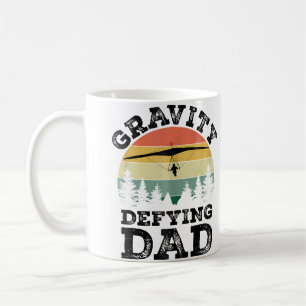 Vater beim Hängegleiten, der der Schwerkraft trotz Kaffeetasse
