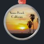 Venice Beach California Sunset Souvenir Ornament Aus Metall<br><div class="desc">This photographic image shows tall palm trees in silhouette standing against a gorgeous vivid yellow, golden, orange, and red sunset over the Pacific Ocean in Venice Beach, California. Add optional text or your vacation dates for a one of a kind unique souvenir. Another original exclusive design by Sonja Quidama Image...</div>