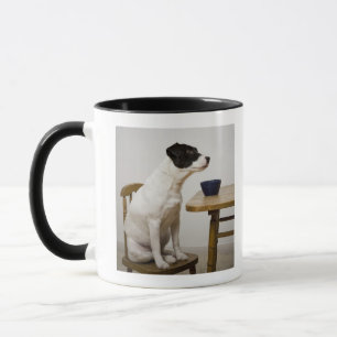 Verfolgen Sie das Sitzen auf einem Stuhl vor einer Tasse