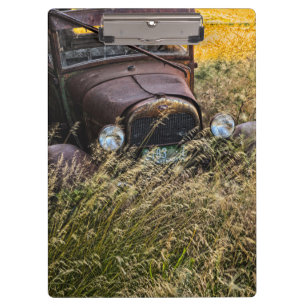 Verlassenes altes Auto im hohen Gras Klemmbrett